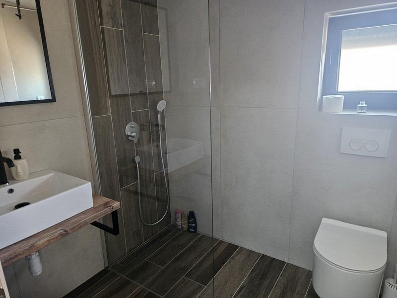 Salle de bains avec douche et meuble vasque