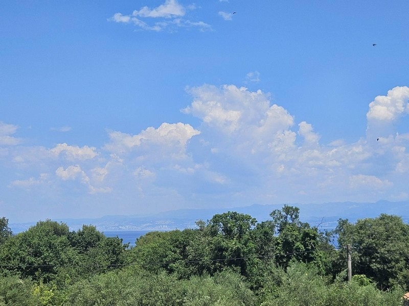 Vue mer depuis le balcon par-dessus les arbres jusqu'au continent