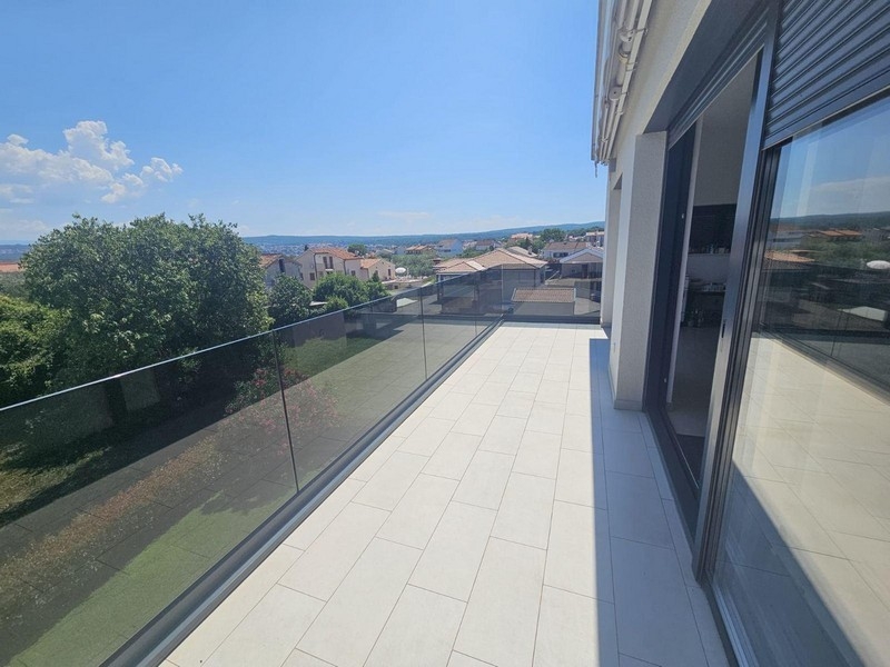 Grand balcon avec garde-corps en verre et vue mer