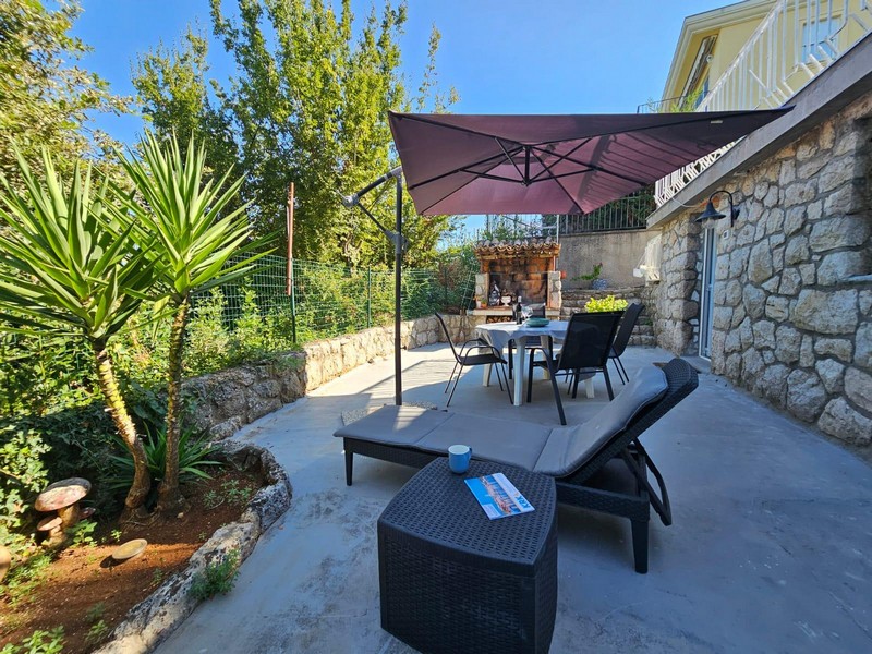 Terrasse avec lounge et parasol de l'appartement du rez-de-chaussée à Njivice