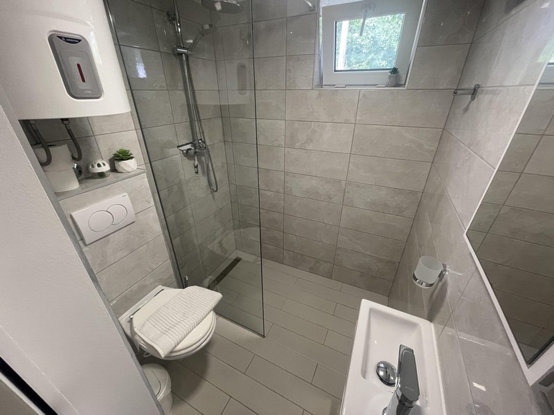Salle de bains avec douche à l'italienne dans l'appartement à Njivice
