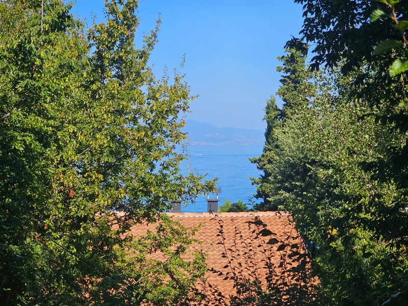 Vue mer depuis l'appartement à Njivice par-dessus les arbres