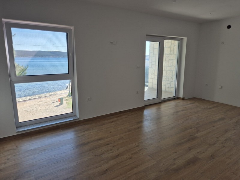 Pièce de vie avec porte donnant sur la terrasse et vue sur la mer