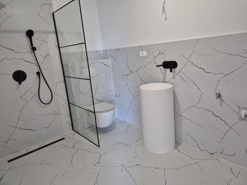 Salle de bains avec douche et toilettes