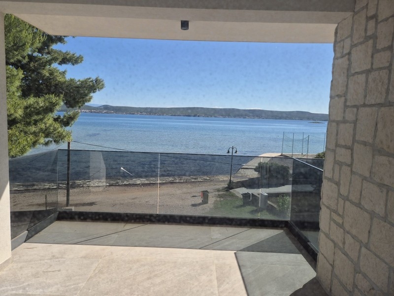 Terrasse couverte avec garde-corps en verre et vue mer