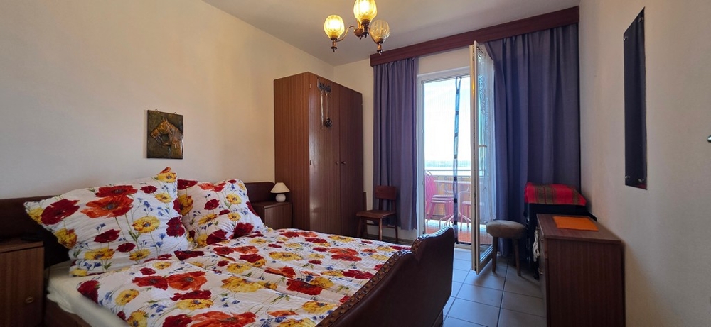 Chambre avec lit double et porte donnant sur le balcon, appartement A4103