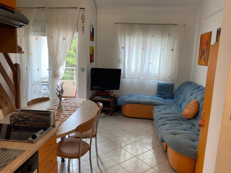 Pièce de vie avec canapé et porte donnant sur la terrasse