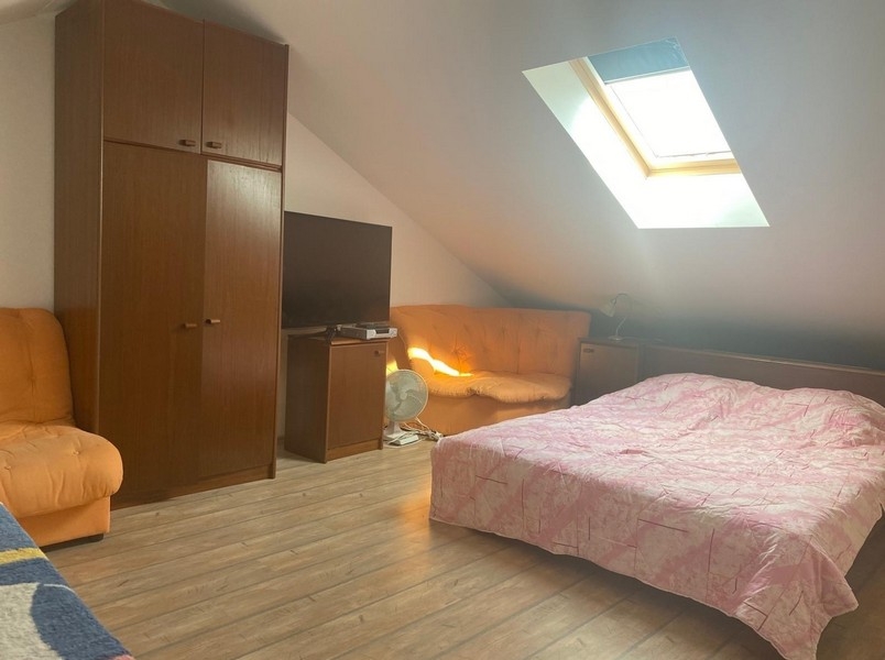 Chambre sous le pan de toit incliné sur la mezzanine