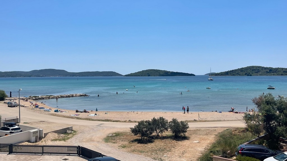Plage de galets et vue mer devant la construction neuve à Srima près de Vodice