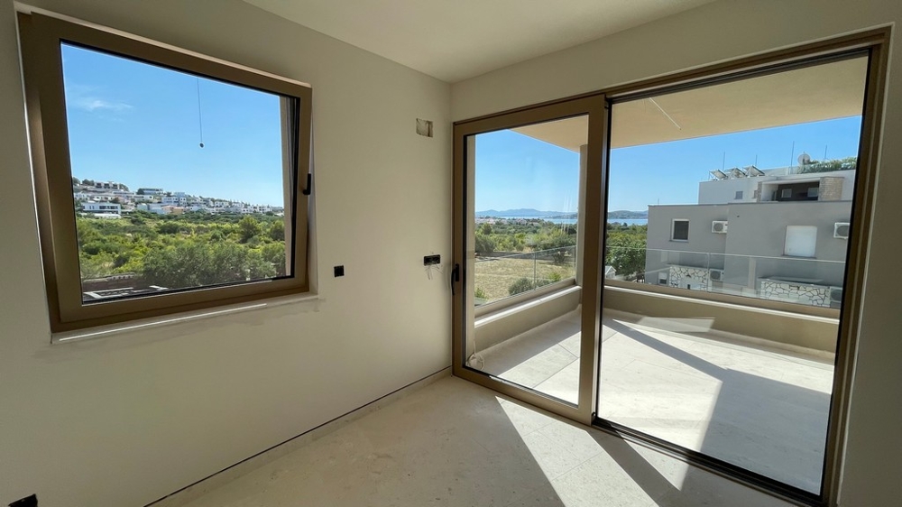 Séjour avec porte coulissante vitrée donnant sur la terrasse et vue mer