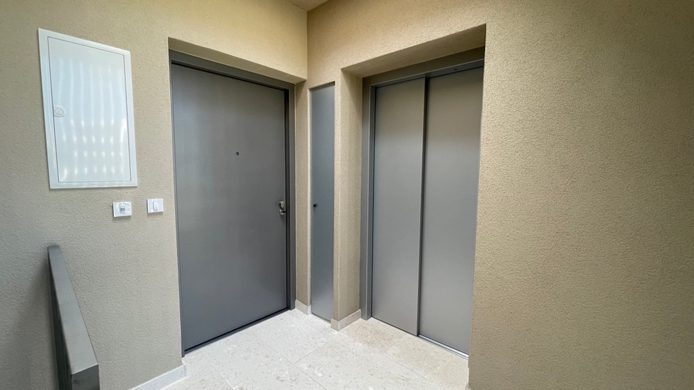 Entrée avec porte d'appartement et ascenseur