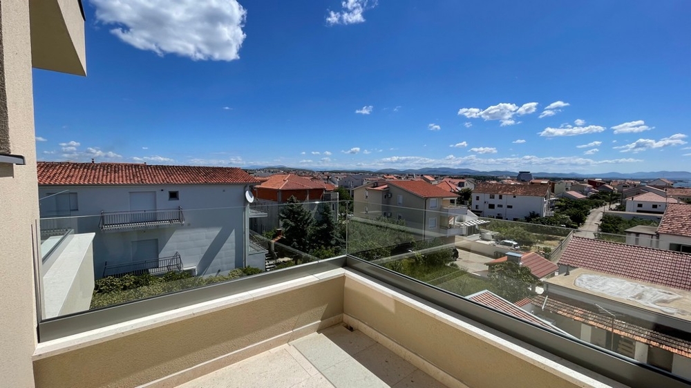 Terrasse avec garde-corps en verre et vue sur les toits de Vodice