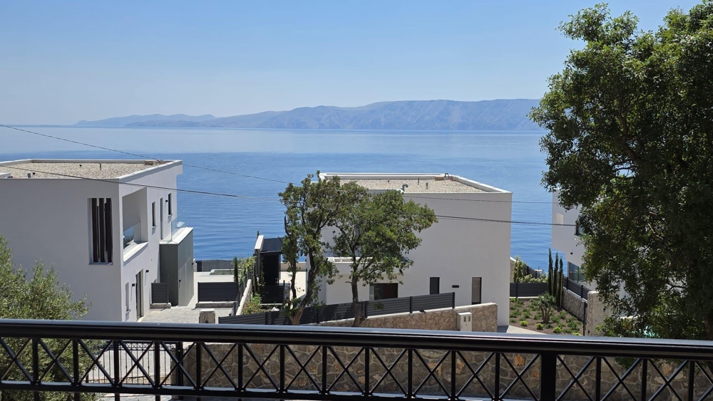 Vue depuis le balcon entre des maisons blanches sur la mer et les montagnes