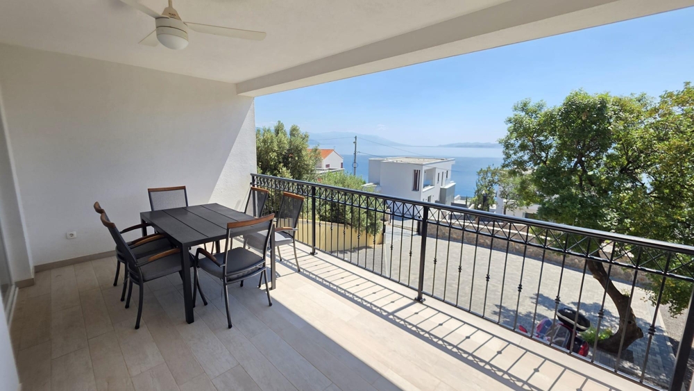 Loggia avec table à manger et vue sur la mer