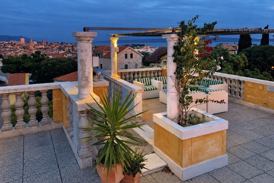 Toit-terrasse du penthouse à Split avec plantes et vue du soir
