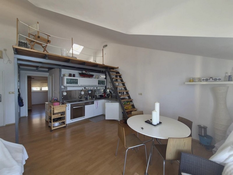 Séjour ouvert avec cuisine et mezzanine sous le toit