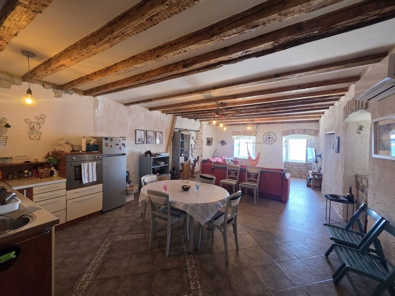 Séjour et espace repas avec plafond à poutres en bois dans l'appartement à Senj