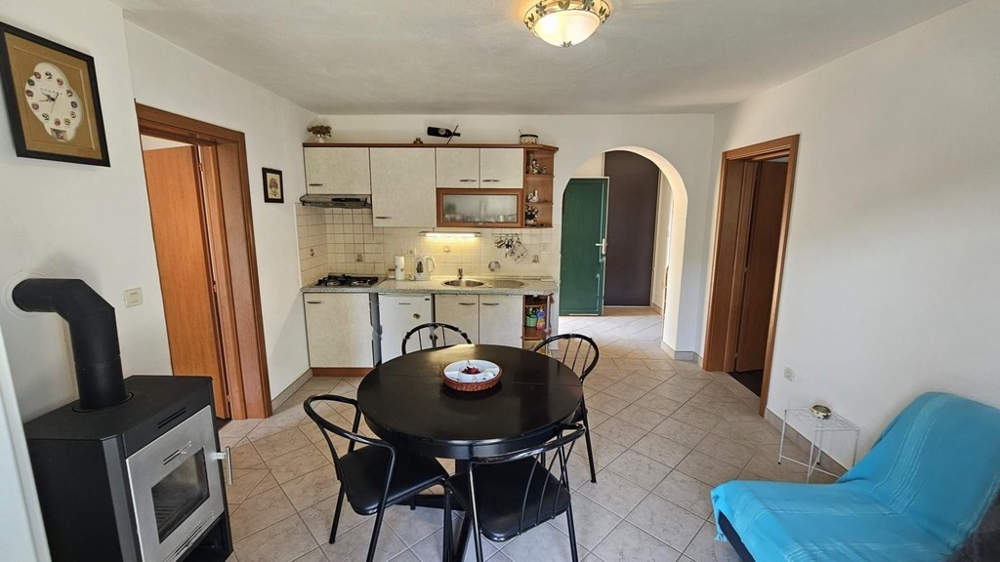Cuisine avec espace repas et poêle à bois dans la pièce de vie