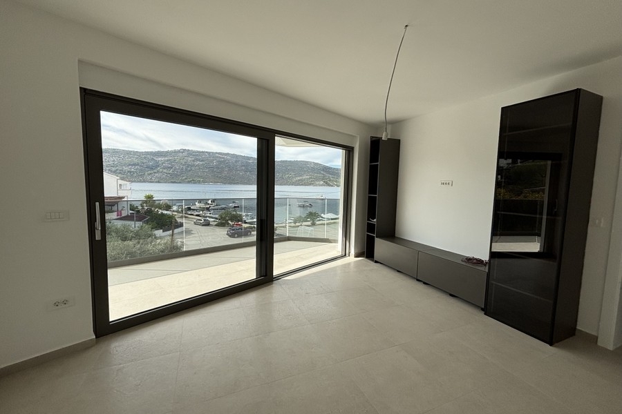 Salon avec baie vitrée à hauteur d'étage et vue mer