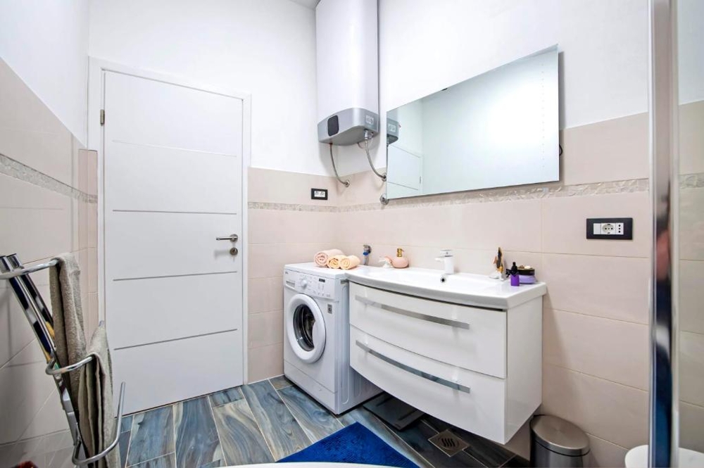 Salle de bains avec meuble vasque et chauffe-eau