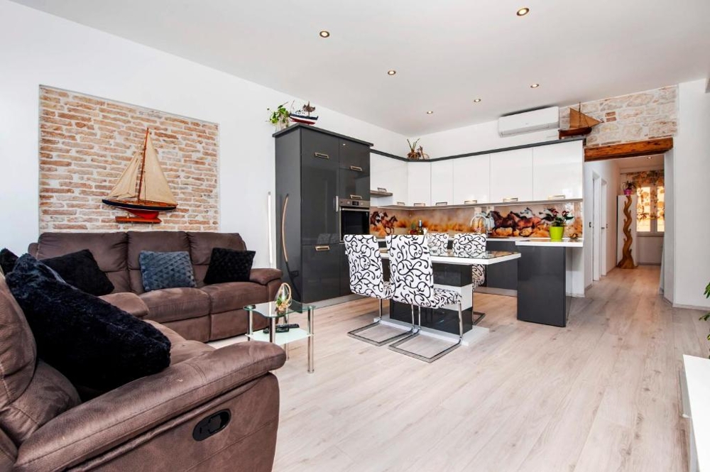 Pièce de vie avec mur en brique et cuisine ouverte