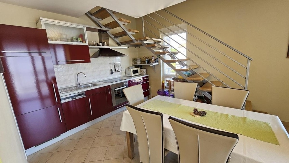 Cuisine ouverte avec espace repas et escalier