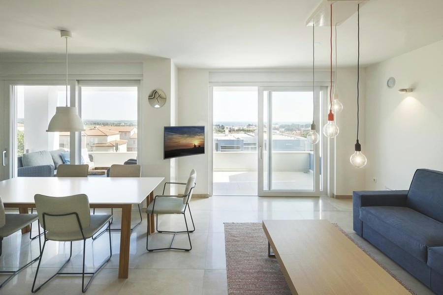 Séjour lumineux avec espace repas et vue vers la terrasse
