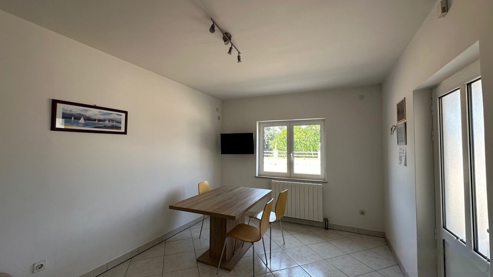 Salon avec table à manger et fenêtre donnant sur la terrasse