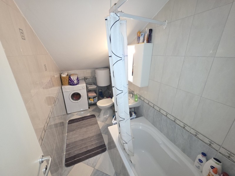 Salle de bains avec baignoire et lave-linge
