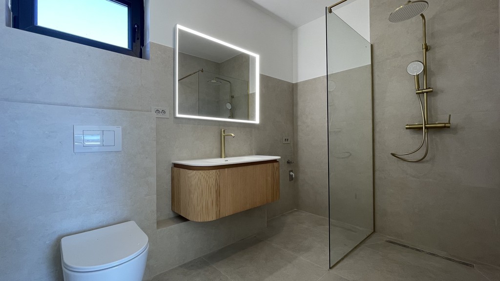Salle de bains avec douche à effet pluie et miroir éclairé