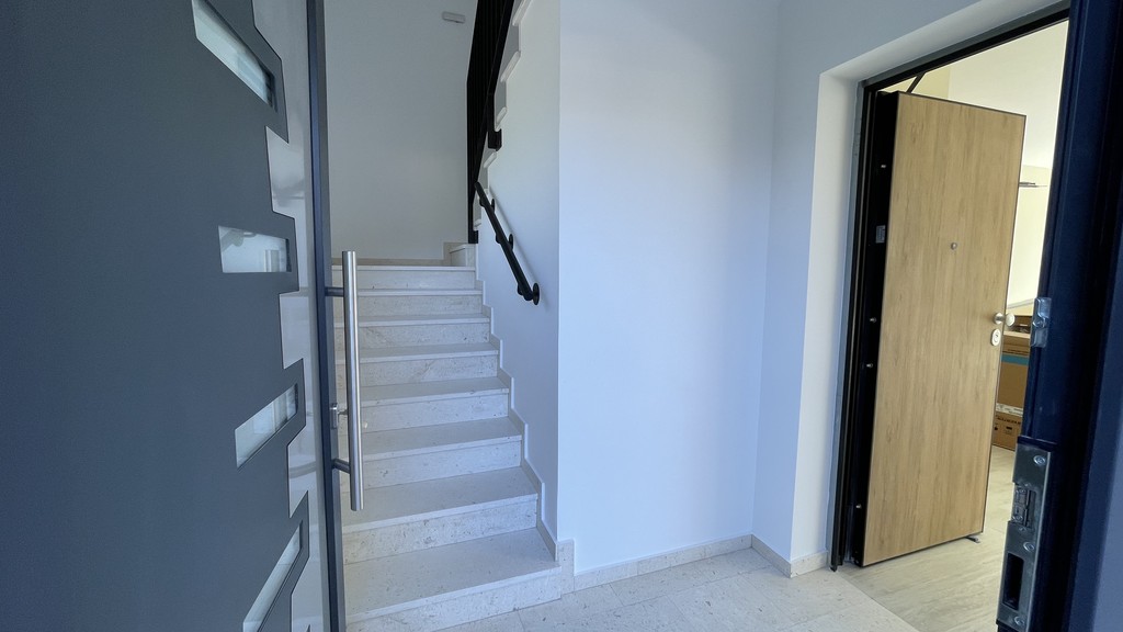 Cage d'escalier et porte d'appartement au rez-de-chaussée