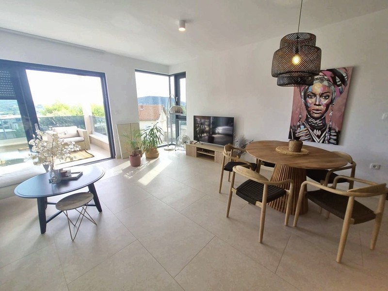 Salon avec espace repas et porte donnant sur la terrasse