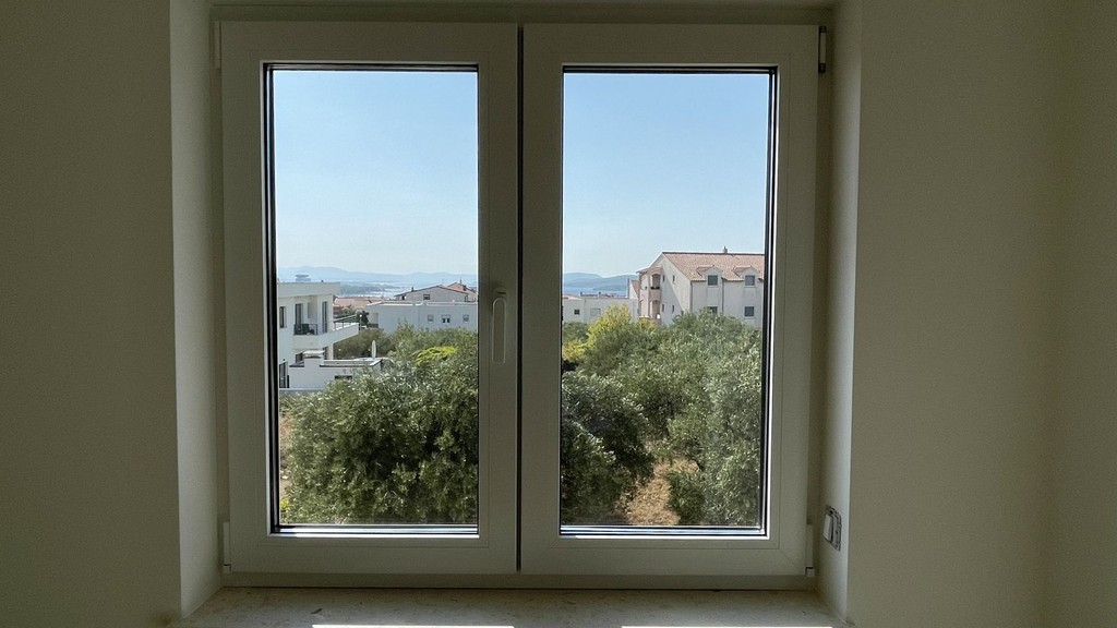 Porte-fenêtre avec vue sur les oliviers