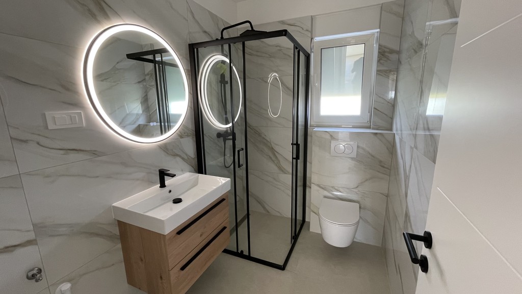 Salle de bains avec douche et miroir éclairé