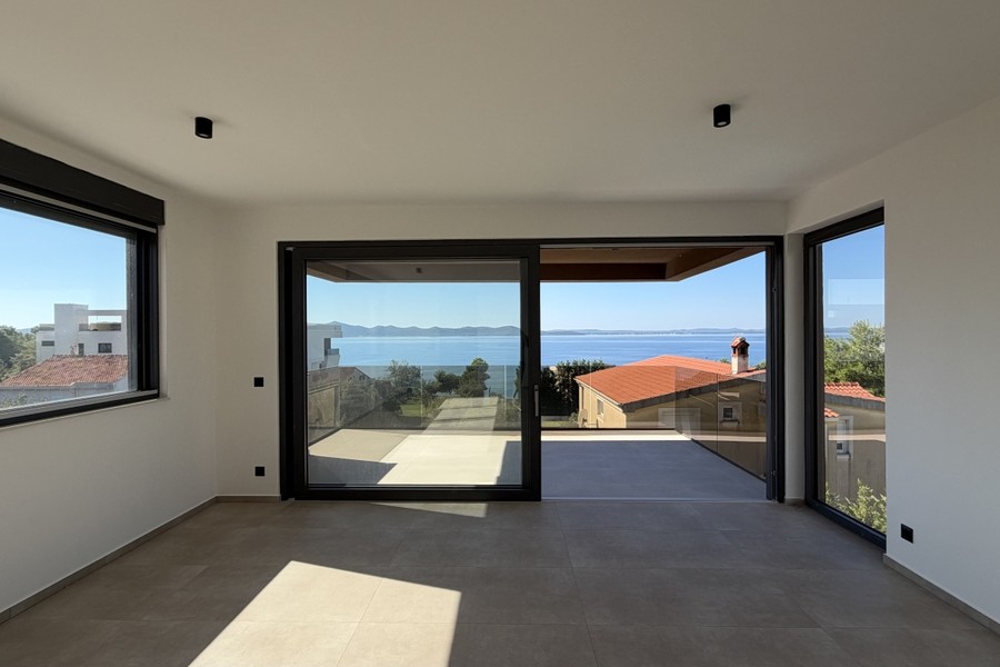 Pièce de vie avec grandes baies vitrées donnant sur le balcon