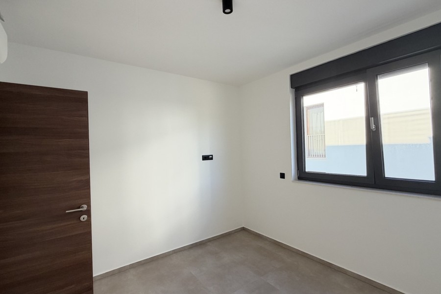 Chambre avec porte en bois et fenêtre donnant sur la rue