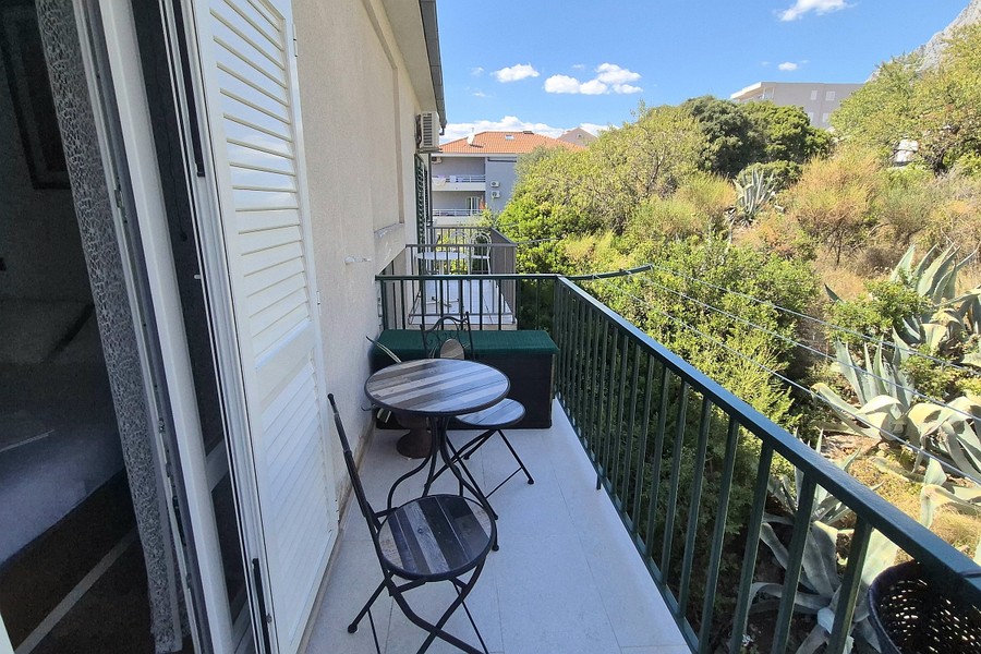 Balcon avec table de bistrot et vue sur la verdure
