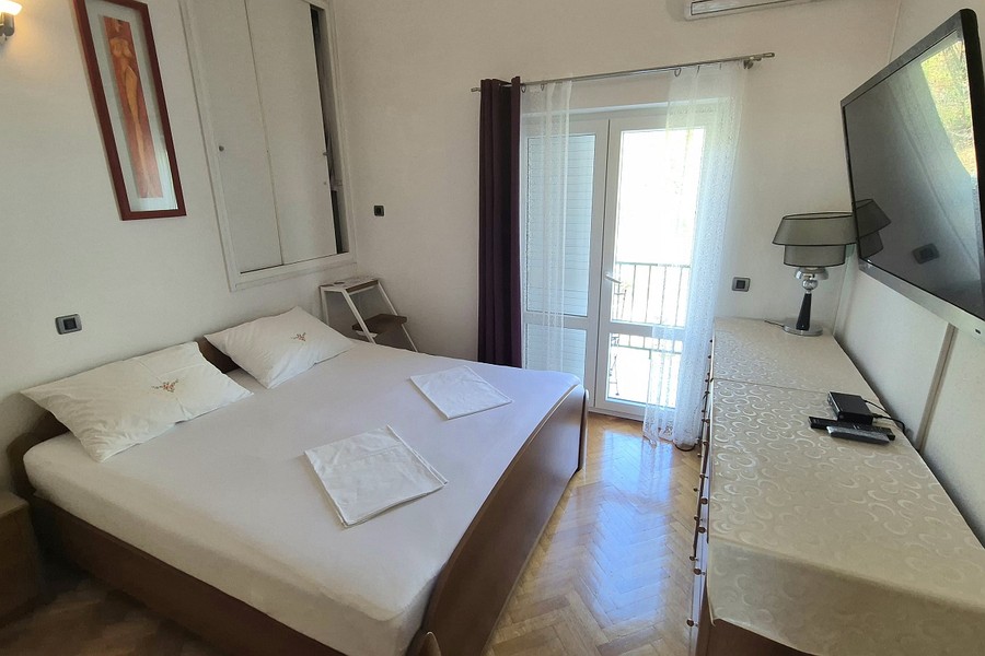 Chambre avec lit double et porte donnant sur le balcon