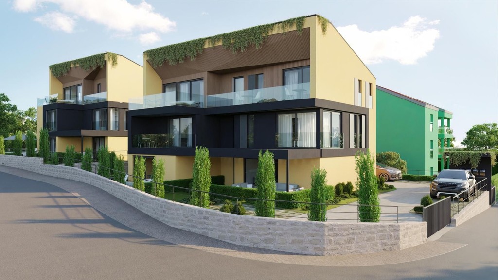 Constructions neuves jaunes avec balcons en verre, toits végétalisés et mur en pierre