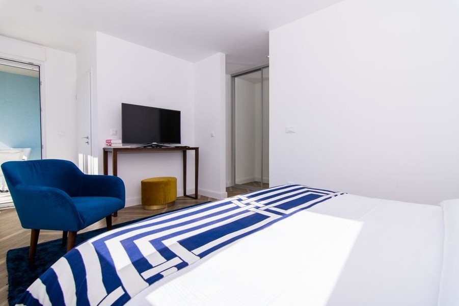 Chambre avec fauteuil et téléviseur