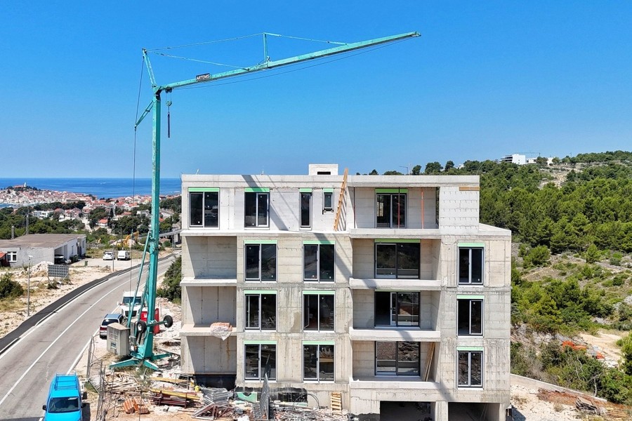 Chantier avec grue, à gauche la vieille ville au bord de la mer