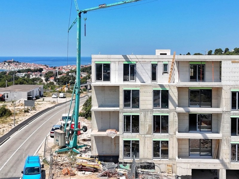 Gros œuvre avec grue, derrière la vieille ville au bord de la mer
