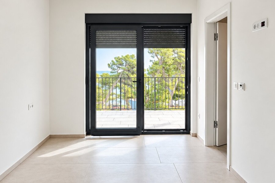 Chambre avec porte-fenêtre sur le balcon et vue sur la verdure