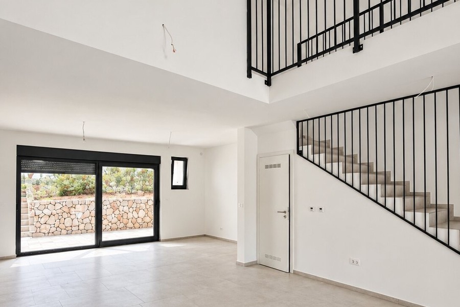 Espace de vie avec mezzanine et porte coulissante vers la terrasse