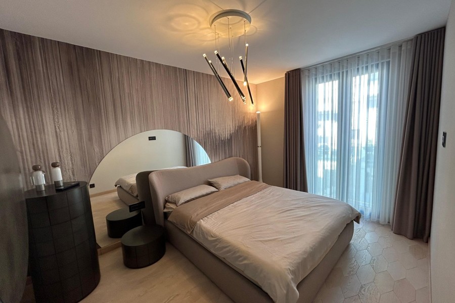 Chambre avec lit capitonné et luminaire design