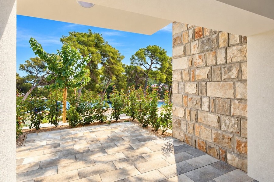Terrasse donnant sur le jardin avec mur en pierre