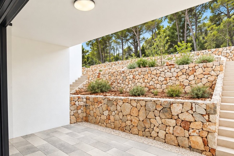 Jardin avec murs en pierre naturelle et plantes