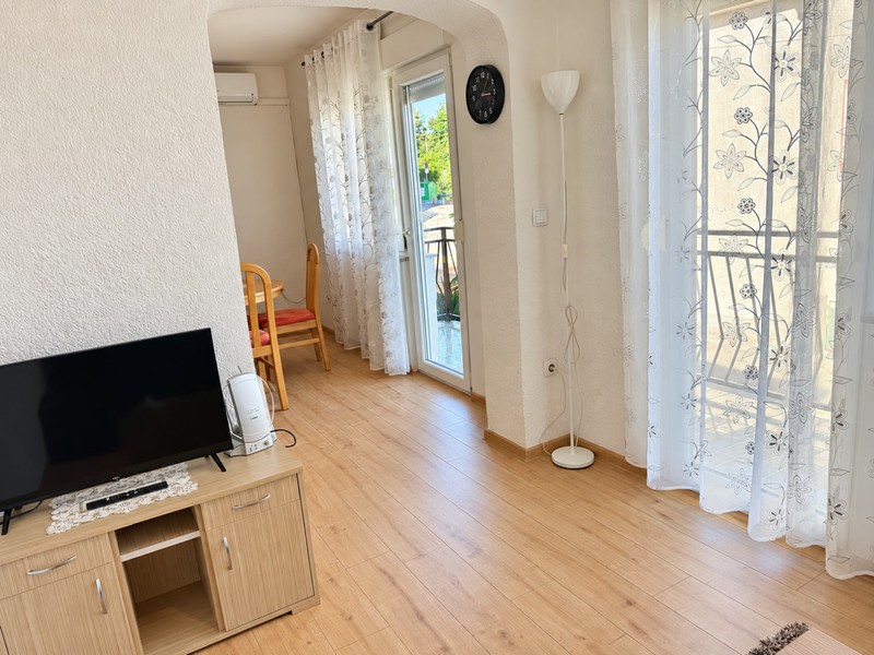 Espace de séjour avec téléviseur et porte-fenêtre du balcon