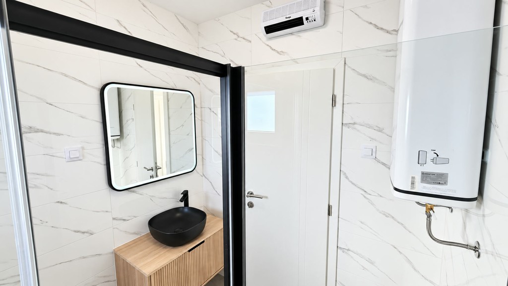 Salle de bain avec miroir et chauffe-eau