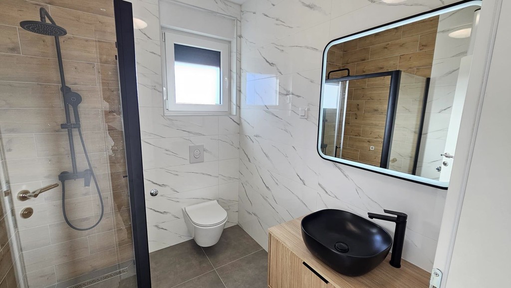 Salle de bains avec douche et miroir mural